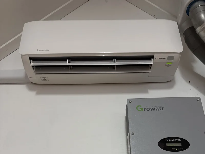 Airco-binnenunit aan de wand boven een omvormer