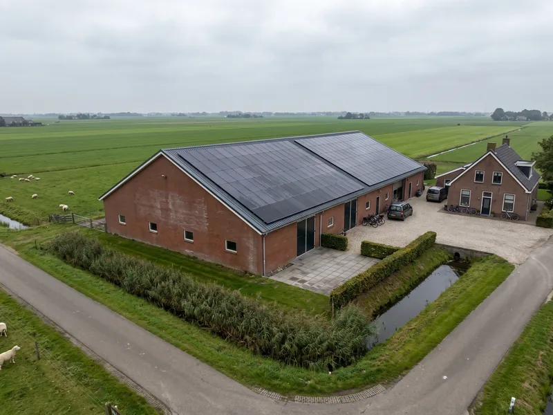 Grote schuur in de polder met zonnepanelen op het dak