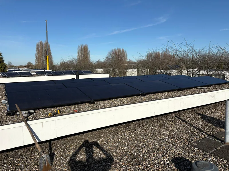 Lange rij zonnepanelen op een groot plat dak