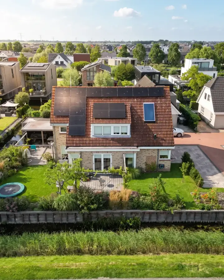 Woning met zonnepanelen op het dak aan de rand van de polder