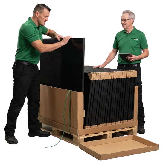 Twee monteurs van Solar Green bij een pallet zonnepanelen uit eigen voorraad