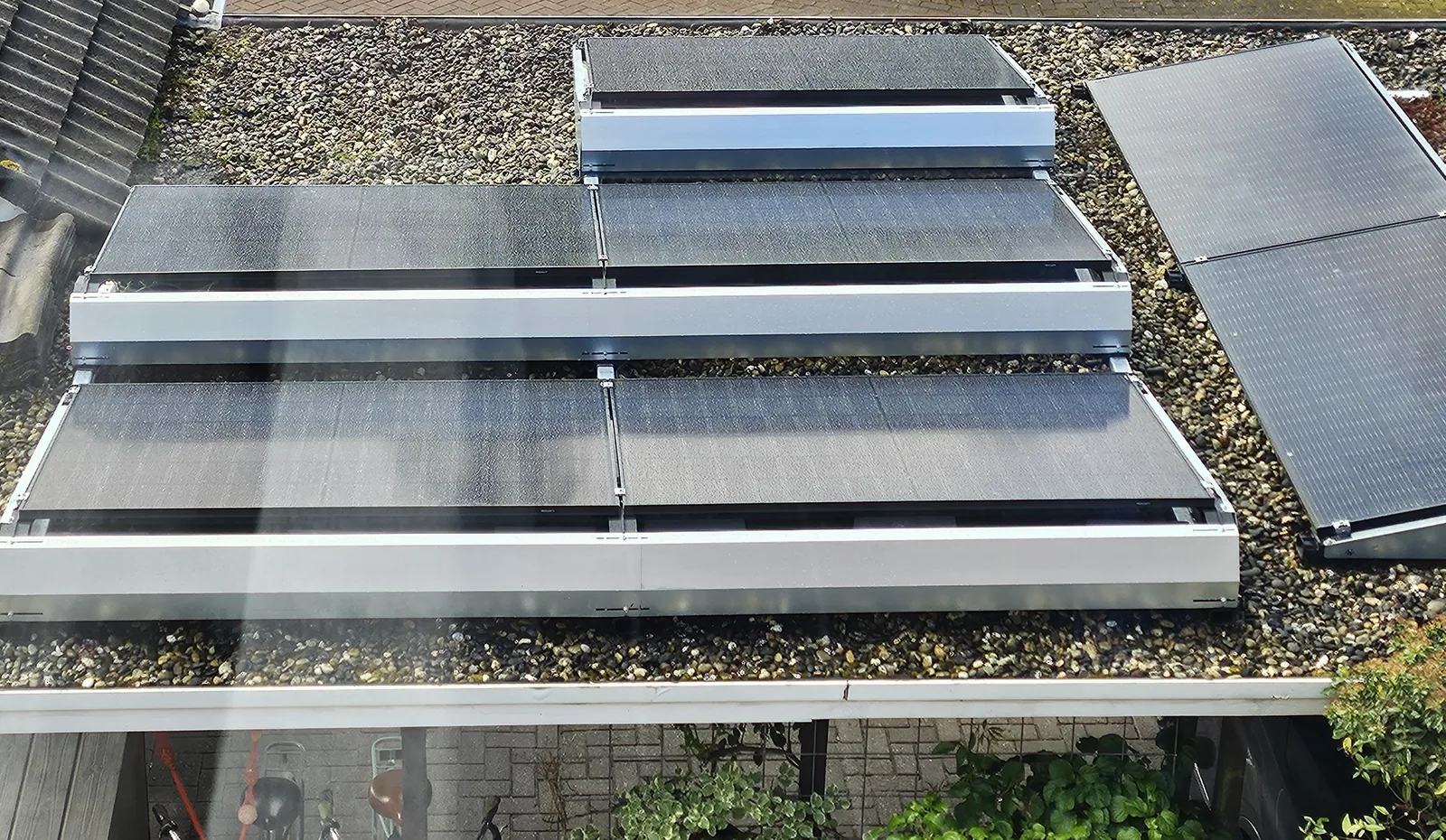 Zonnepanelen op frames op een plat grinddak