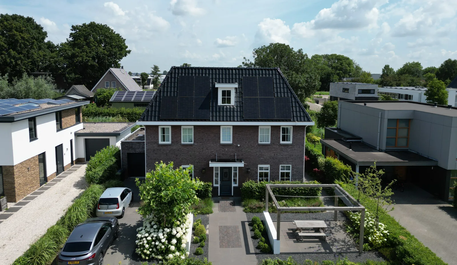 Vrijstaande woning met zwarte zonnepanelen op het dak, van bovenaf