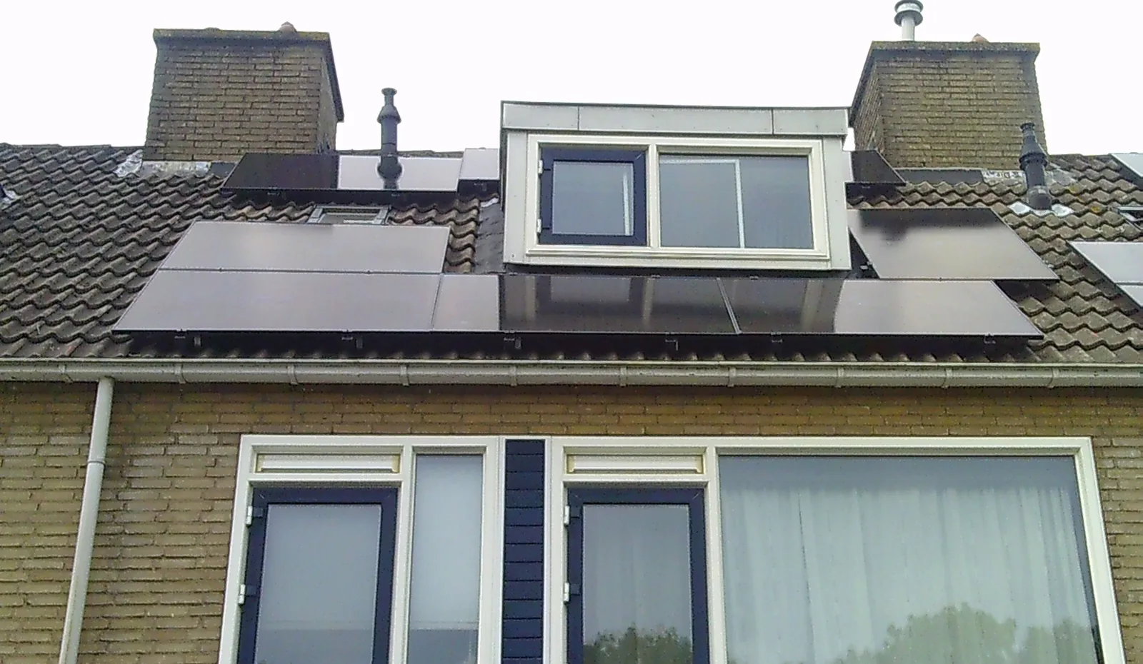 Pannendak met een dakkapel en zwarte zonnepanelen