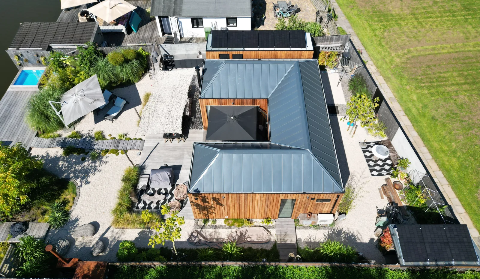 Woning met tuin en zonnepanelen op de bijgebouwen, van bovenaf