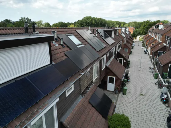 Rij woningen met zonnepanelen op de schuine daken, gezien vanaf het dak