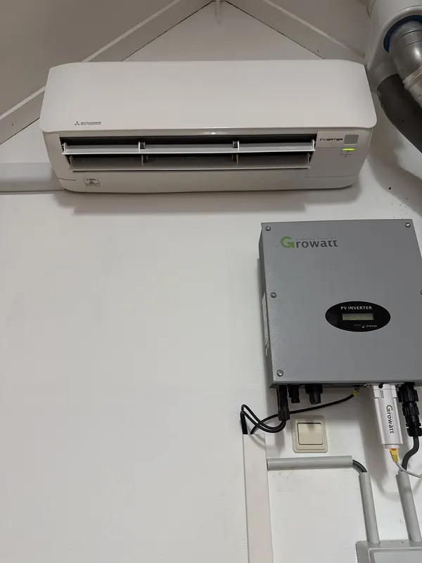 Airco-binnenunit aan de wand boven een omvormer