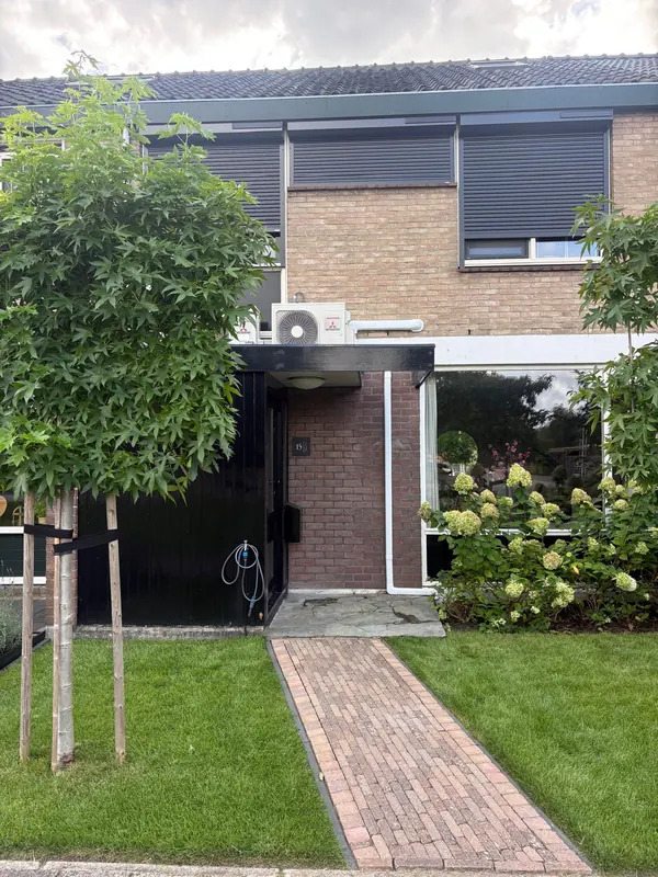 Rijtjeswoning met een airco-buitenunit boven de voordeur