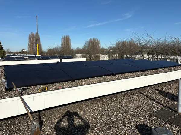 Lange rij zonnepanelen op een groot plat dak