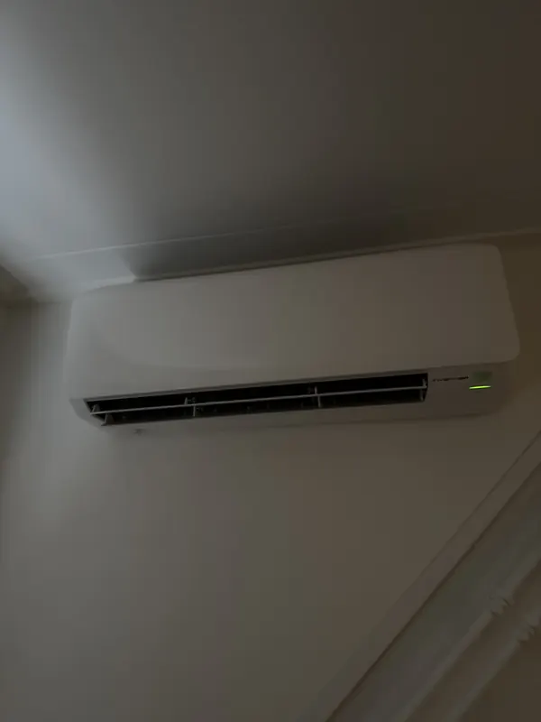 Witte airco-binnenunit hoog aan de wand