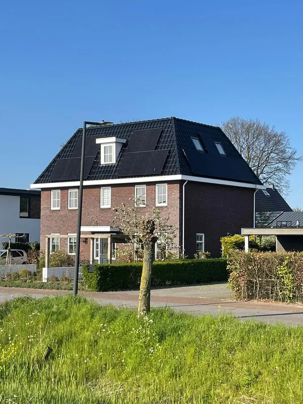 Vrijstaande woning met een zwart dak vol zonnepanelen
