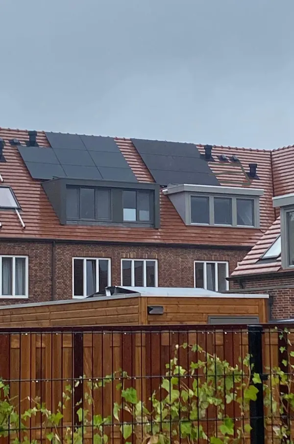 Rij woningen met zonnepanelen rond de dakkapellen