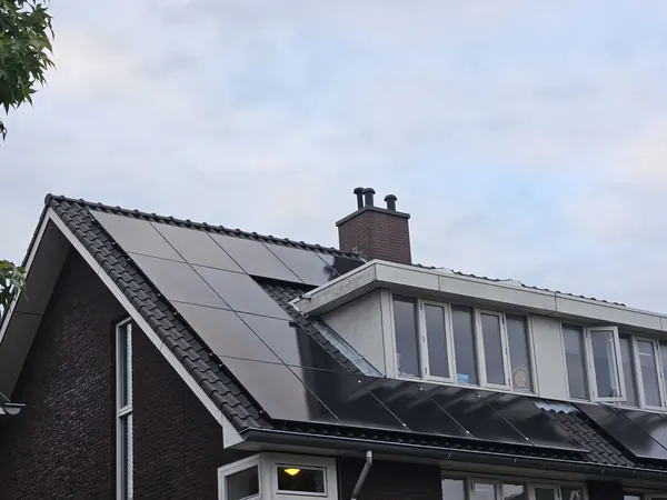 Hoekwoning met zonnepanelen rond een dakkapel