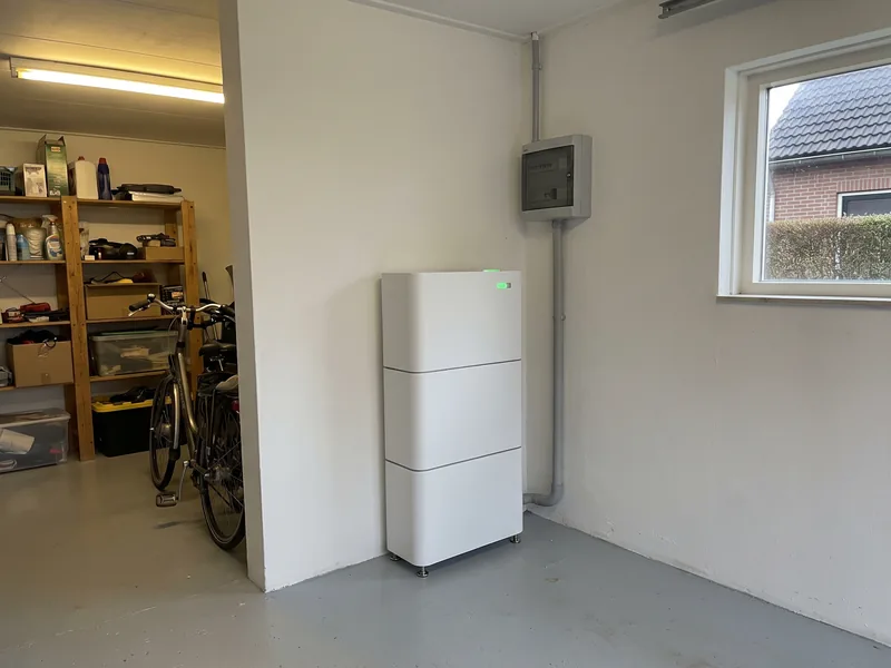 Witte thuisbatterij van drie modules in een opgeruimde berging