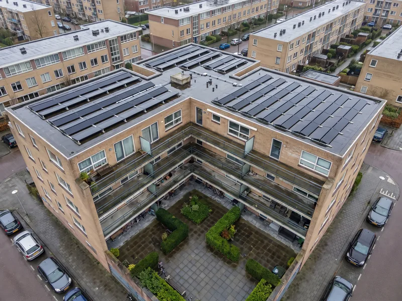 Appartementencomplex rond een binnentuin met zonnepanelen op de daken