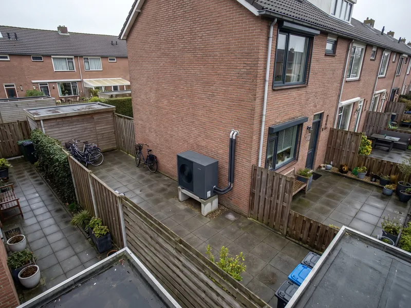 Achtertuinen van rijtjeshuizen van bovenaf, met een warmtepomp tegen de achtergevel
