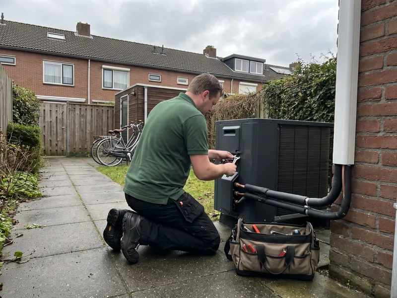 Monteur sluit de leidingen van een buitenunit aan