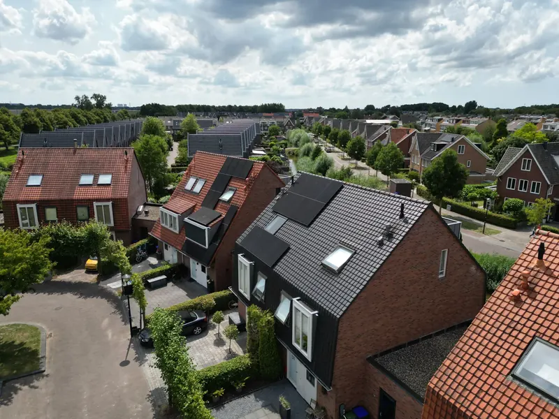 Hoekwoning met zonnepanelen aan een woonerf, van bovenaf