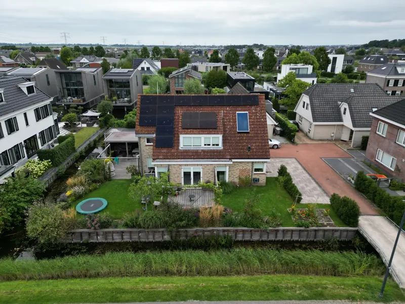 Woning met zonnepanelen op het dak en een grote tuin, van bovenaf